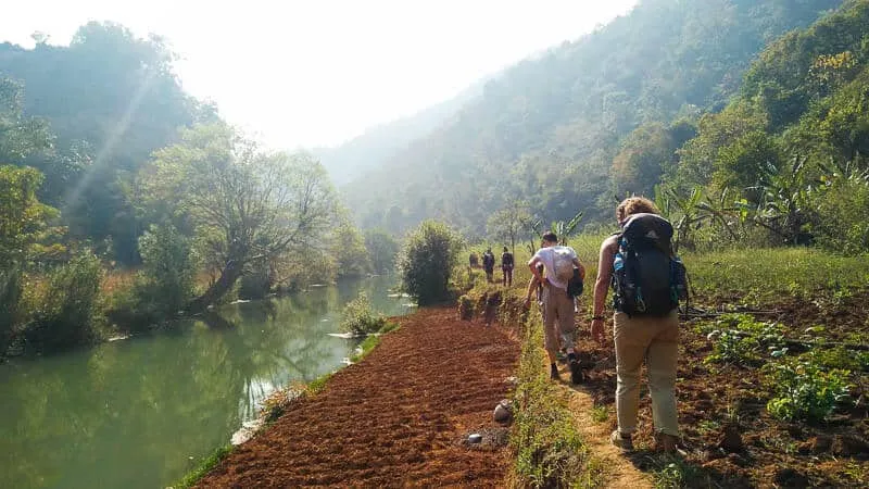 Friends Hiking through Farms and River in the Kalaw Hike in Myanmar
