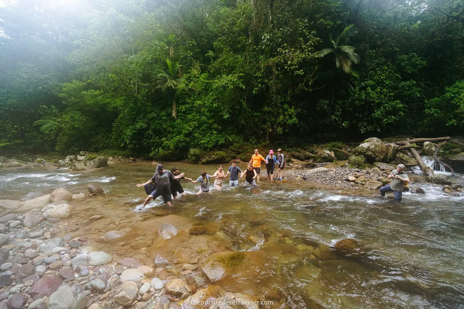 Crossing the river with rubber boots and swimming shorts